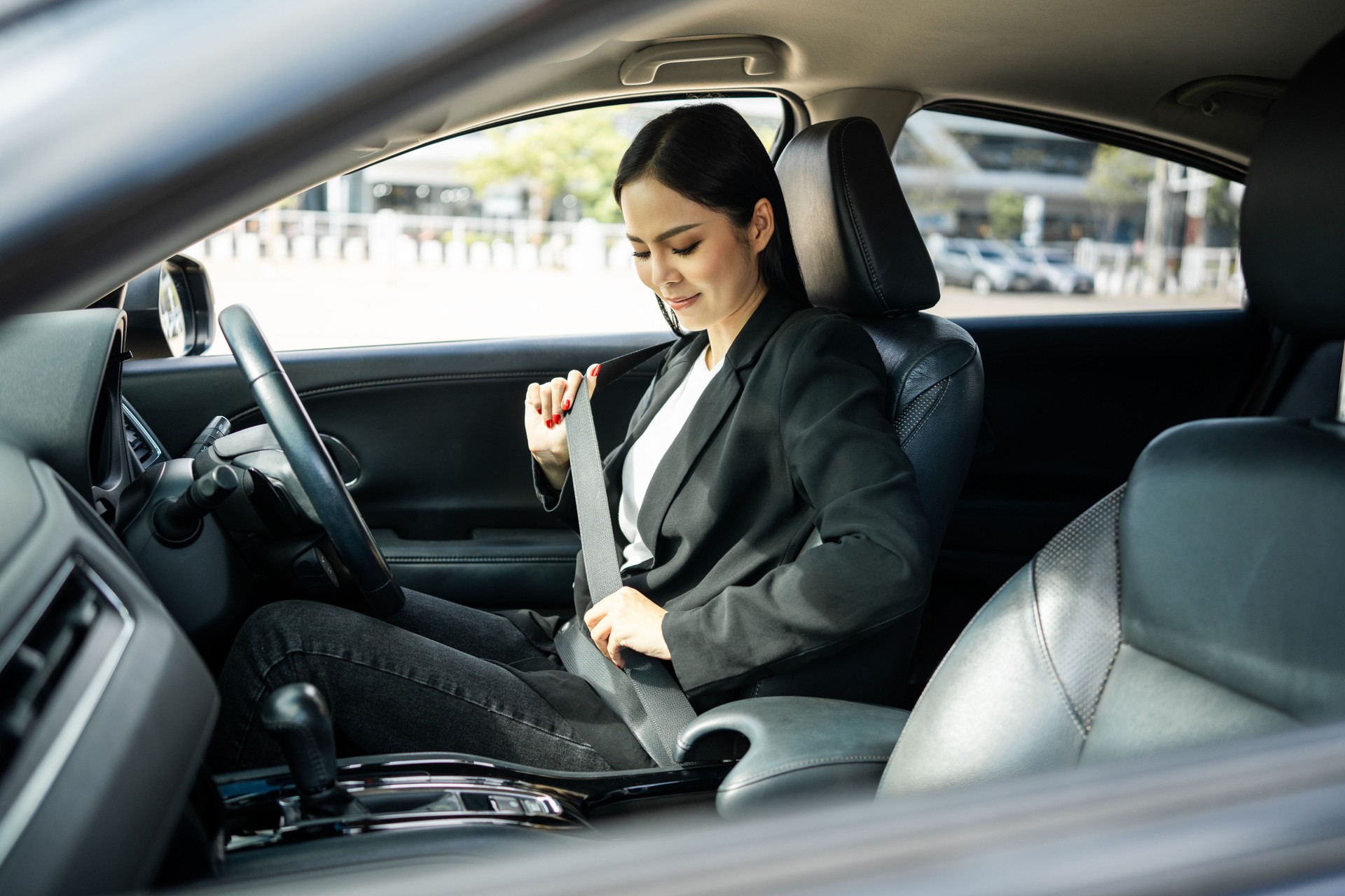 Jovens mulheres de negócios asiáticas bonitas recebendo carro novo colocado no cinto de segurança. ela muito feliz e animada sentar e colocar o cinto de segurança. Mulher sorridente comprando carro novo veículo de condução de segurança na estrada